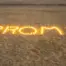 Candles on a beach used to create a high school promposal.